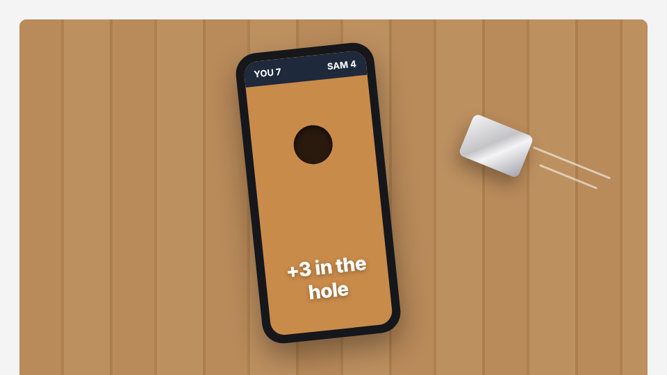 A foil-wrapped sugar packet sliding toward a phone lying on a wooden table